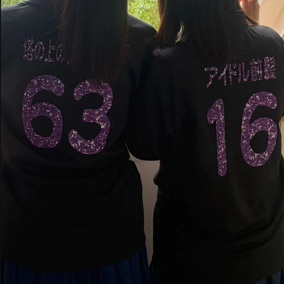 紫のラメで背ネームと背番号をプリントした黒いオリジナルTシャツ